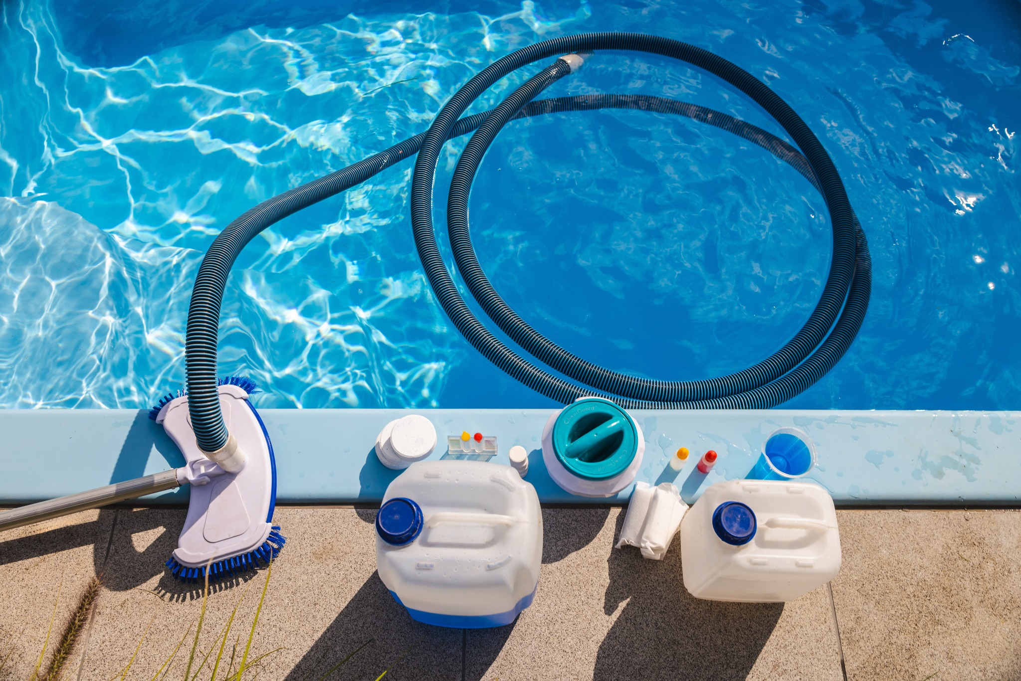 Pool cleaning equipment and supplies beside clear blue water