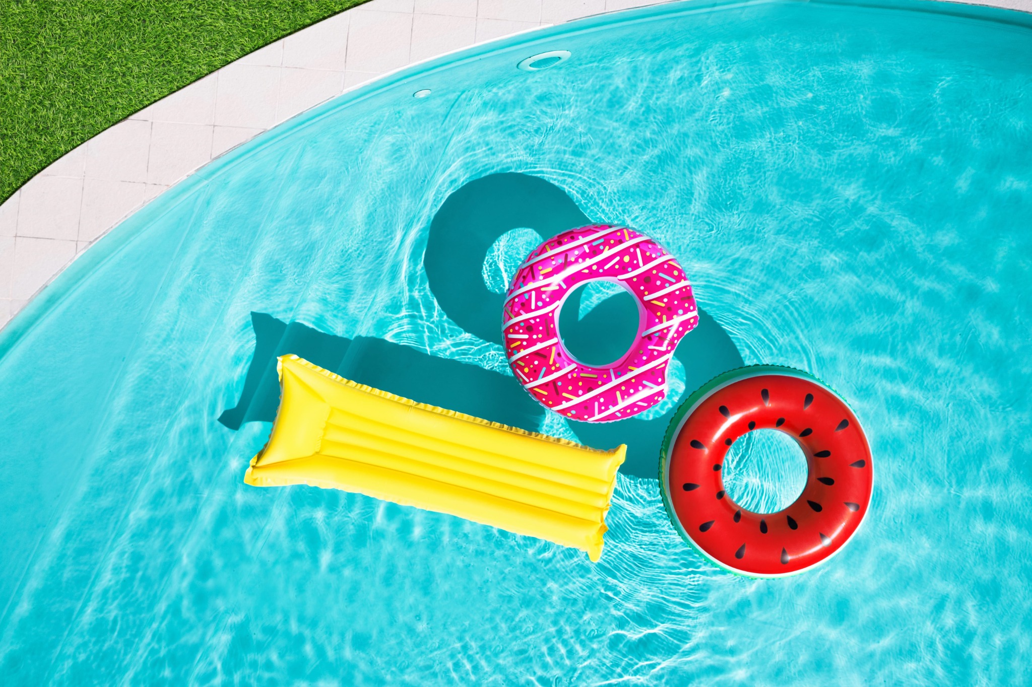 Colorful floats on sparkling blue pool water